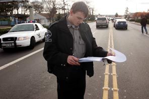 Cadet Baz, with Pierce County Sheriff's department, checks people in and out of the crime scene Sunday, Nov. 29, 2009 near Parkland, Washington where four police officers were shot to death Sunday morning inside Forza Coffee at 11401 Steele Street South.
