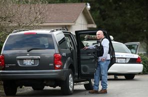 A police officer stands near the Tacoma house of Maurice Clemmons, the 37-year-old former Arkansas man wanted for questioning in the killing of four Lakewood officers near Parkland on Sunday morning. 
