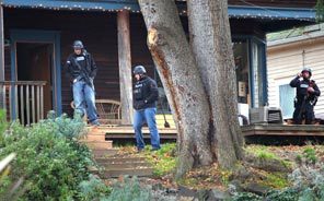 Seattle Police search the Leschi neighborhood at Erie Avenue near Superior Street for the suspect who shot and killed four Lakewood Police officers on Sunday.