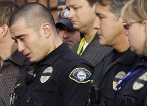 Lakewood police officers become emotional at a press conference Monday. Four fellow officers were shot to death Sunday as they sat in a coffee shop. 