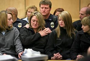 Kelly Richards, widow of slain Lakewood Police Officer Greg Richards, center, and their daughter Jami-Mae, center right, are comforted at a court hearing for three people accused of assisting Maurice Clemmons. Behind Kelly is her brother-in-law, Tacoma Police Officer Steve Thornton.