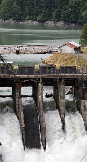 Water crashes over Elwha Dam as Lake Aldwell is drawn down. The dam is one of two that soon will be removed in an effort to restore salmon runs. 