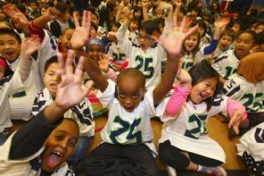 Excited children show their spirit during an assembly Friday at Kimball Elementary School in Seattle to celebrate the Seahawks jerseys they all received because of nearly $25,000 raised in an online effort by teacher Kevin Zelko. The money bought 447 jerseys for all of the school's students, many of whom come from homes that can't afford them. 