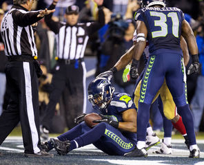 Malcolm Smith cradles the ball he intercepted in the play against the San Francisco 49ers that sent the Seattle Seahawks to the Super Bowl.