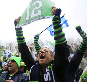 Janice Linton, who recently moved here from Los Angeles and quickly became an avid Seahawks fan, holds a 12th Man sign during a fan rally Wednesday at Seattle Center.