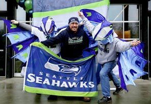 Daniel Castillo, center, poses for pictures at a Seahawks fan rally Wednesday at Seattle Center. The longtime Seahawks fan said he was "muy feliz." Many other Seahawks fans also are feeling very happy as the Super Bowl nears, and signs of support are seen everywhere.