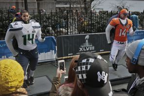 Fans make souvenir photos posing with Seahawks and Broncos cutouts on Super Bowl Boulevard in New York City. 