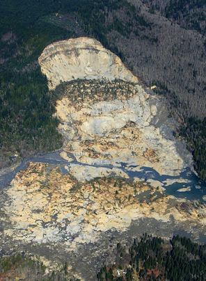 This aerial photo, taken after Saturday’s landslide, shows part of the plateau that has been logged over the decades. Right above where the hill fell away is a 7½-acre patch, shaped like a triangle, that was clear-cut about nine years ago. 