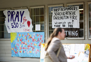 A shopper heads Monday into the Darrington IGA, which is covered with signs of support for mudslide victims and first responders. 
