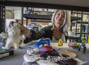  July Andre, the property-reunification manager, grabs a Pillsbury Doughboy doll off the shelf of objects still waiting to be claimed at a Snohomish County administration building in Everett. About 450 objects and 1,500 photos remain unclaimed from the Highway 530 landslide. 