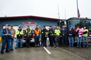 Pastor Mike DeLuca, left, says a prayer as rescue workers and community members gather outside the Darrington Fire District 24 station one week after the slide, on March 29. DeLuca has been a central figure in the long-term recovery effort.